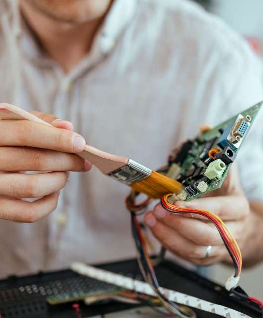 A person trying to clean their PC hard drive with a brush.