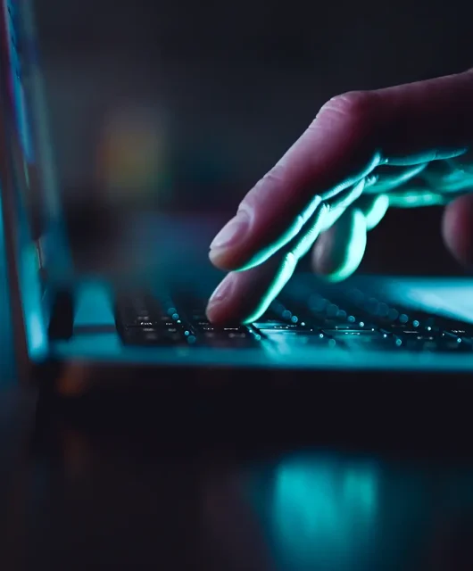 A man’s hand browsing on a laptop.